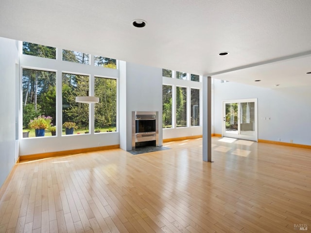 unfurnished living room featuring baseboards and light wood-type flooring