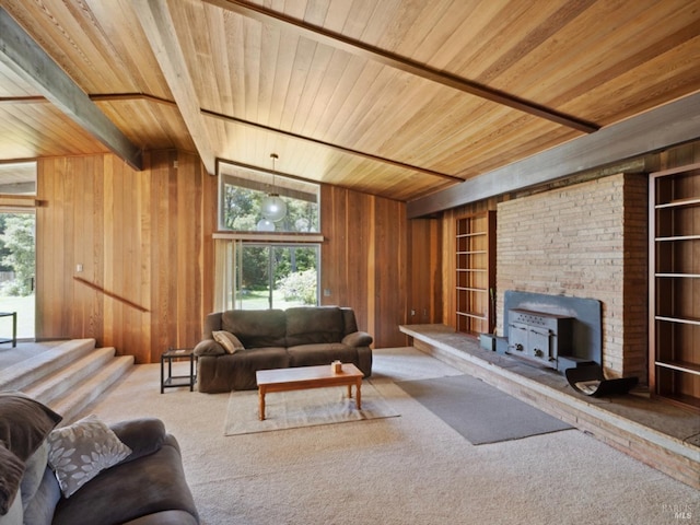 carpeted living room featuring wood ceiling, a wood stove, wood walls, built in shelves, and beamed ceiling