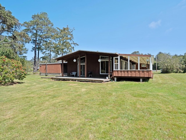 back of house with a wooden deck and a yard