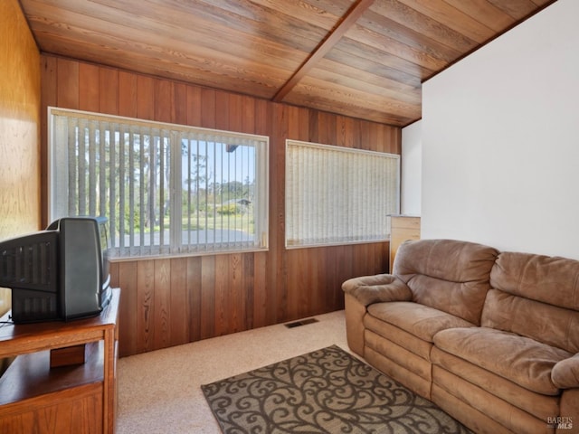 carpeted living room featuring wooden walls, wooden ceiling, and visible vents