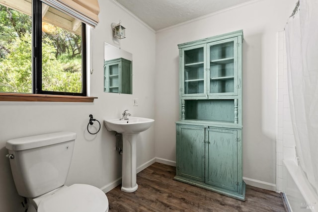 full bathroom with ornamental molding, wood finished floors, toilet, baseboards, and a sink