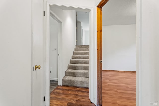 stairs featuring baseboards and wood finished floors