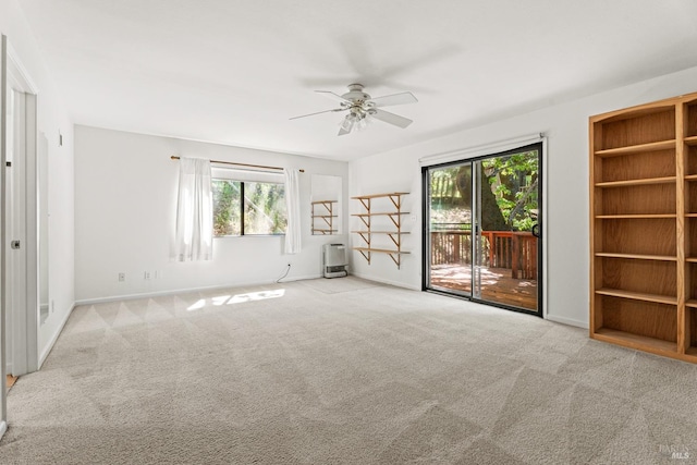 empty room with carpet floors, plenty of natural light, baseboards, and a ceiling fan
