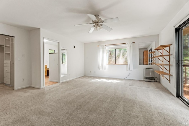 spare room featuring baseboards, ceiling fan, and light carpet