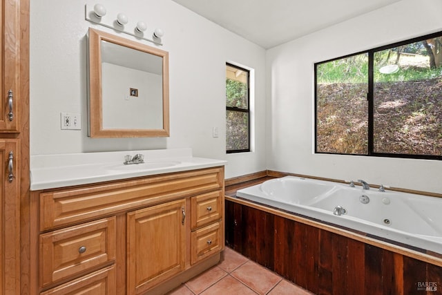 bathroom with a healthy amount of sunlight, vanity, tile patterned flooring, and a whirlpool tub