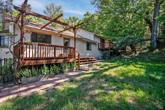 rear view of house with a lawn and a deck