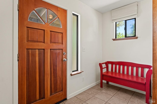 foyer entrance with baseboards and light tile patterned floors