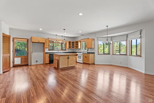 kitchen with black dishwasher, light wood-style floors, white range with gas stovetop, and a sink