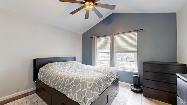 bedroom featuring a ceiling fan, baseboards, lofted ceiling, and light wood-style floors