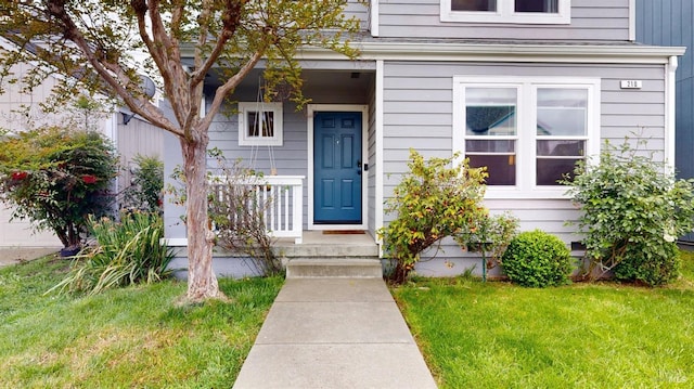 view of exterior entry with a lawn