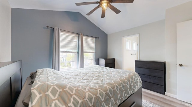 bedroom featuring baseboards, a ceiling fan, light wood-style flooring, and lofted ceiling