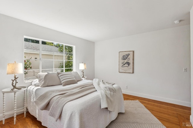 bedroom with baseboards and wood finished floors