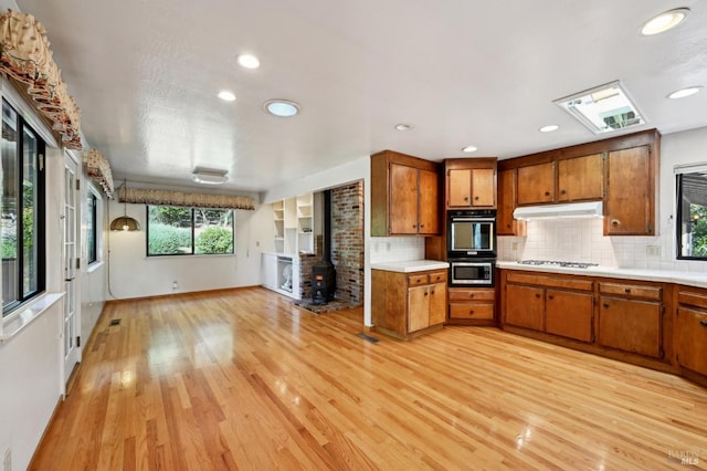 kitchen featuring brown cabinetry, light countertops, and light wood-style flooring