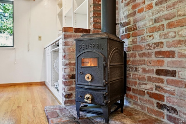 details with a wood stove, wood finished floors, and baseboards