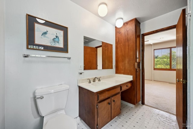 half bathroom with tile patterned floors, toilet, and vanity