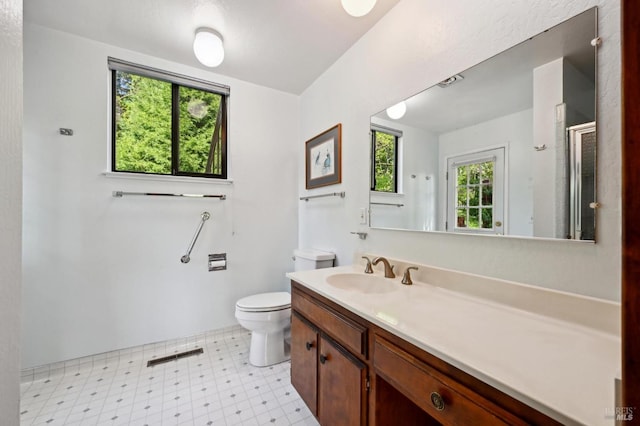 bathroom with tile patterned floors, toilet, vanity, and a shower with shower door