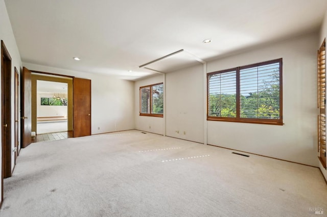 carpeted empty room with recessed lighting