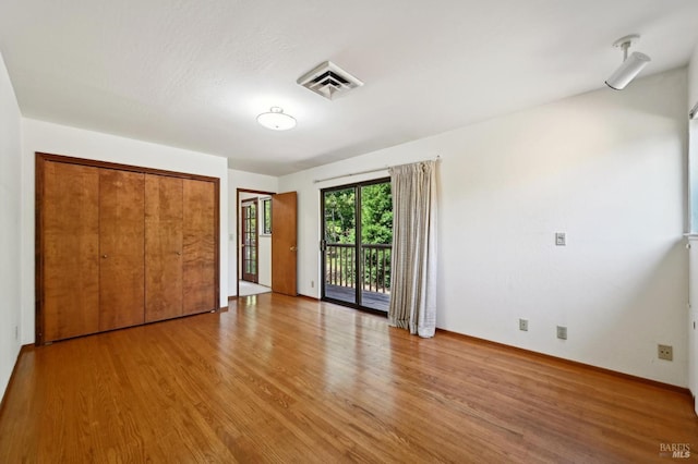 unfurnished bedroom featuring baseboards, visible vents, light wood-style flooring, and access to exterior