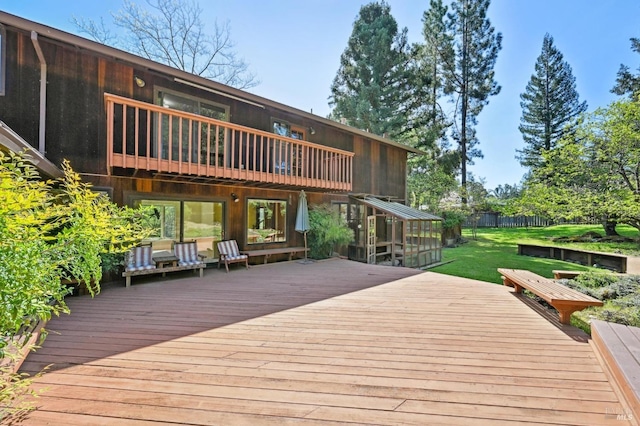 wooden terrace featuring a lawn and fence