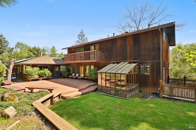 rear view of property with a yard, a balcony, an outbuilding, an exterior structure, and a deck