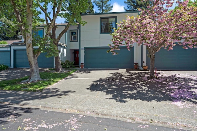 view of front of home with a garage, stucco siding, and driveway