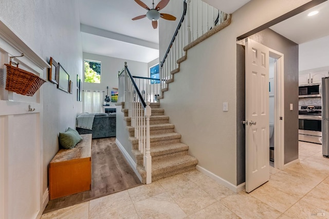 staircase featuring a ceiling fan, tile patterned floors, and baseboards