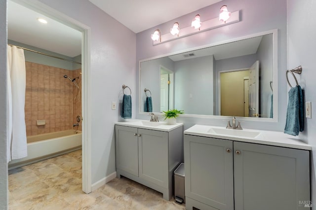 bathroom featuring visible vents, a sink, two vanities, and shower / bath combo