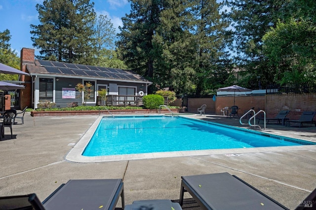 community pool featuring fence and a patio area