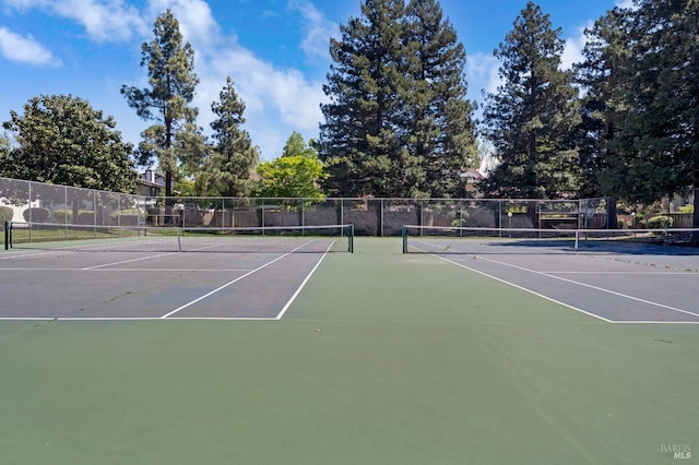 view of tennis court featuring fence and community basketball court