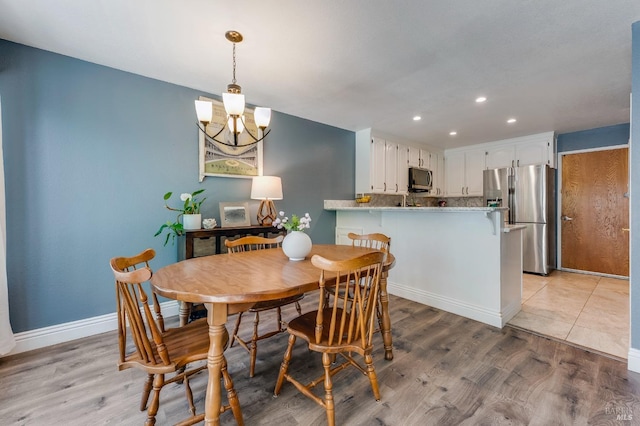 dining space featuring recessed lighting, light wood-style floors, baseboards, and a chandelier
