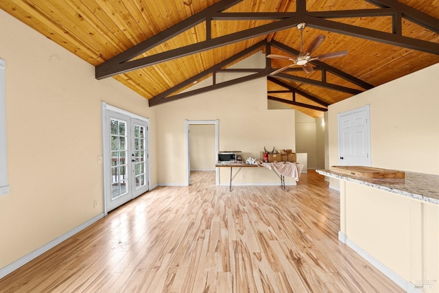 unfurnished living room with beam ceiling, french doors, light wood-style flooring, baseboards, and wood ceiling
