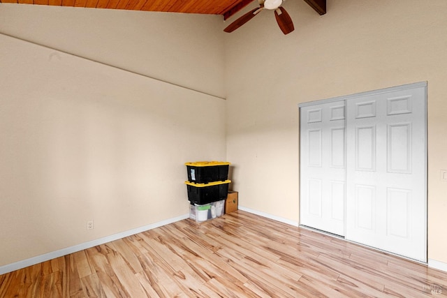unfurnished bedroom featuring a ceiling fan, wooden ceiling, baseboards, high vaulted ceiling, and light wood finished floors