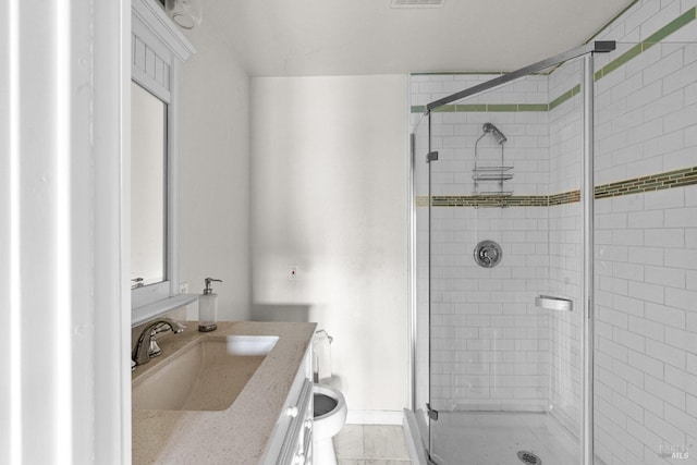bathroom featuring vanity, toilet, and a shower stall