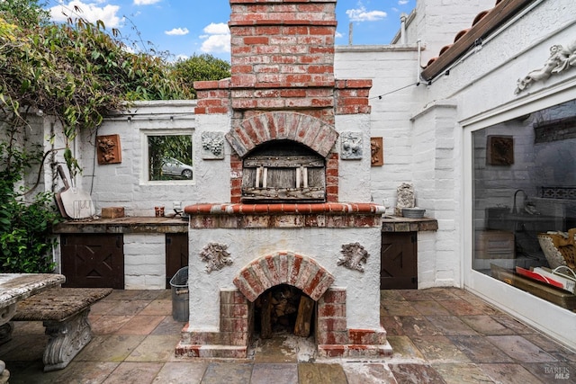 view of patio featuring an outdoor brick fireplace