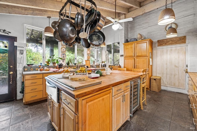 kitchen with ceiling fan, beamed ceiling, beverage cooler, wood counters, and a high ceiling