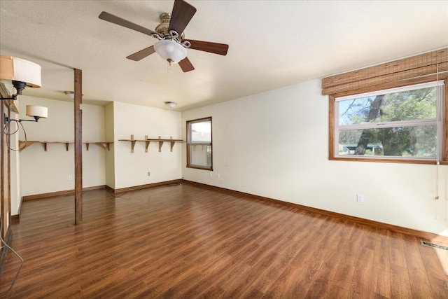 spare room featuring baseboards, ceiling fan, wood finished floors, and visible vents