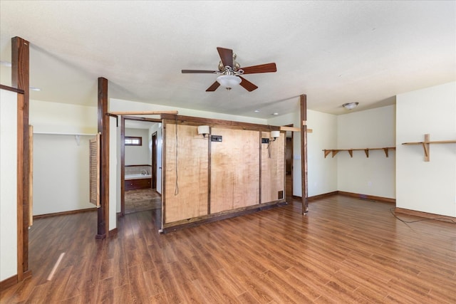 unfurnished living room featuring baseboards, ceiling fan, and wood finished floors