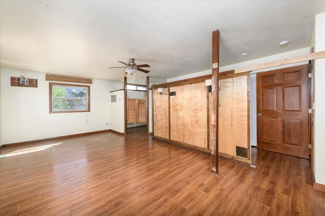 interior space featuring baseboards, a ceiling fan, wood finished floors, and a barn door
