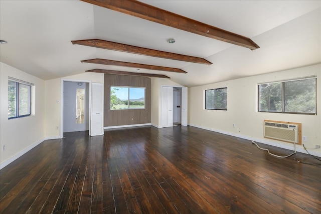 unfurnished living room featuring lofted ceiling with beams, wood-type flooring, baseboards, a wall unit AC, and a wealth of natural light