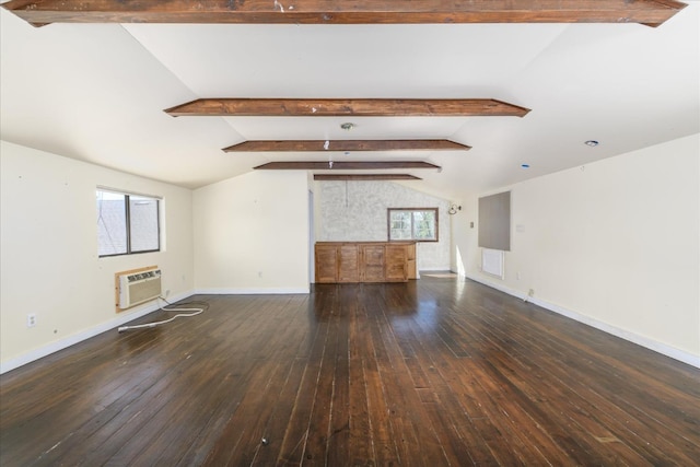 unfurnished living room featuring plenty of natural light, lofted ceiling with beams, a wall mounted AC, and hardwood / wood-style floors