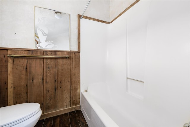 full bath with wood walls, toilet, and wood finished floors