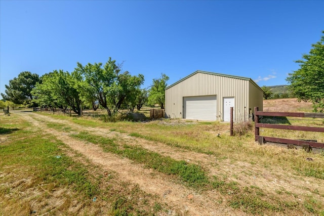 detached garage featuring fence