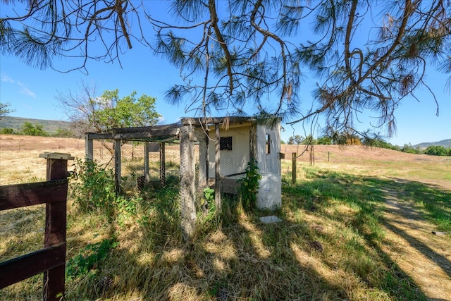 view of outbuilding featuring an outdoor structure and a rural view
