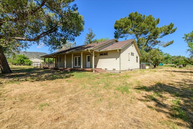 back of house featuring crawl space and french doors
