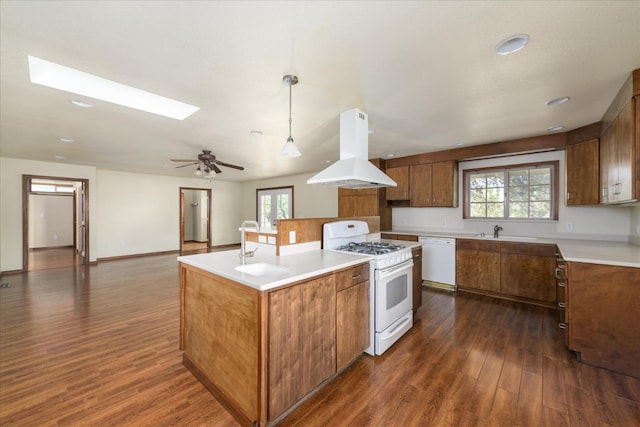 kitchen with brown cabinets, white appliances, dark wood finished floors, a center island, and island range hood