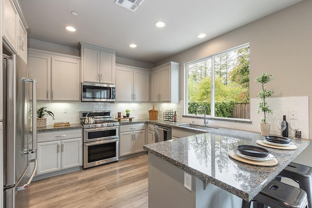 kitchen featuring a sink, stainless steel appliances, recessed lighting, a peninsula, and visible vents