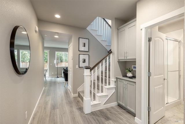 stairway with recessed lighting, baseboards, and wood finished floors
