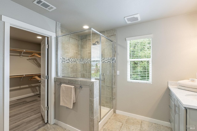 full bath featuring visible vents, baseboards, and a shower stall