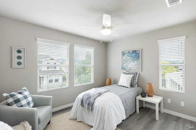 bedroom featuring visible vents, a ceiling fan, baseboards, and light wood-type flooring