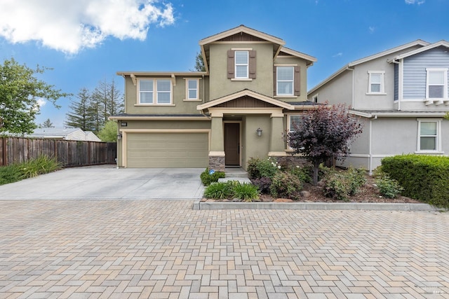 view of front facade featuring concrete driveway, a garage, fence, and stucco siding